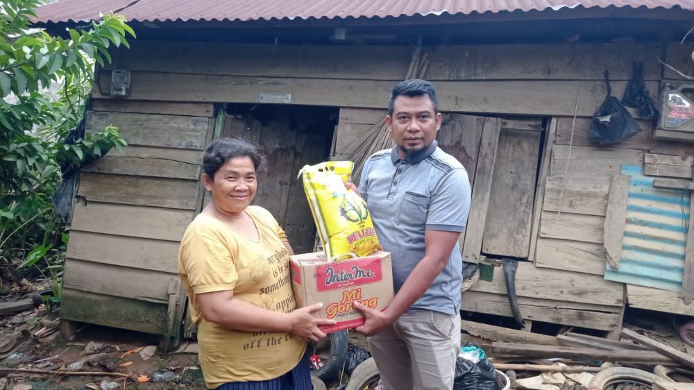 Yadi, Sekertaris SMSI Bungo saat berikan bantuan kepada salah satu warga di kelurahan Jaya Setia..